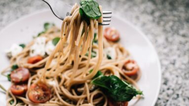 selective focus photography of pasta with tomato and basil